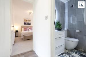 ein Bad mit einem WC und ein Schlafzimmer mit einem Bett in der Unterkunft Luxury Group Stay With Bar, 80-inch TV and Parking - Sleeps 10 - By EKLIVING  + 123 Fotos