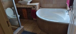 Un baño con bañera y WC. en 7atSapele, en Germiston
