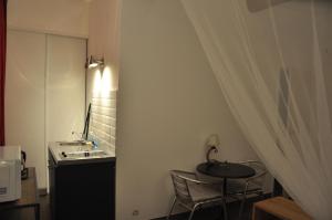 a small room with a table and a sink at location studio meublé avec jardin in Sorgues