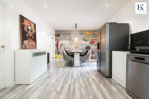 eine Küche mit Tisch und ein Esszimmer in der Unterkunft Luxury Group Stay With Bar, 80-inch TV and Parking - Sleeps 10 - By EKLIVING 