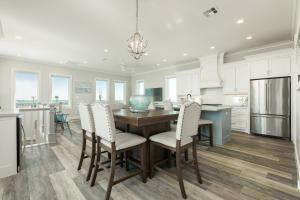 eine Küche und ein Esszimmer mit einem Holztisch und Stühlen in der Unterkunft Luxury Gulf Views Pool Exclusive Villa in Bolivar Peninsula