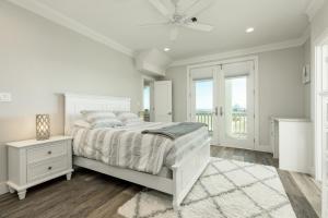 ein weißes Schlafzimmer mit einem Bett und einem Fenster in der Unterkunft Luxury Gulf Views Pool Exclusive Villa in Bolivar Peninsula + 52 Fotos