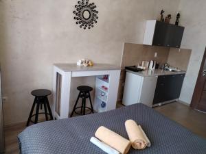 a small kitchen with a table and two bar stools at Studio ISKRA Novi Sad in Pasuljište