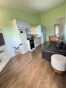 ガロパバにあるApto no Centro de Garopabaの黒いソファとキッチンのあるリビングルーム