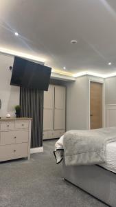 a bedroom with a bed and a flat screen tv at Cloud Quarters II in Wakefield