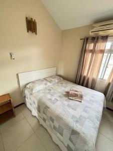 ガロパバにあるApto no Centro de Garopabaのタオルが敷かれたベッドのある寝室