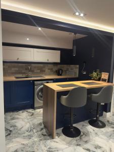 a kitchen with a counter and two bar stools at Cloud Quarters II in Wakefield