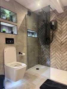a bathroom with a toilet and a glass shower at Cloud Quarters II in Wakefield