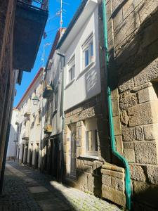 an alley with a stone building next to a street at Casa da Tia Binda in Monção +18 photos