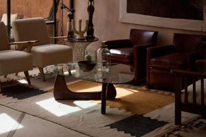 a living room with a glass table and leather chairs at Riad Caravane in Aït Ben Haddou