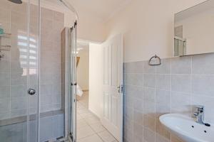 Un baño con lavabo y ducha en Upstairs at 47, en Centurion 17 fotos más