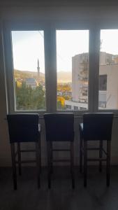 two chairs sitting in front of a window at Central Flat in Prizren
