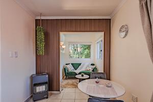 una sala de estar con una mesa y un sofá en Upstairs at 47, en Centurion