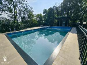 a swimming pool with blue water in a yard at Tree Valley Resort Wayanad in Meppādi