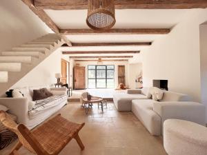 a living room with white furniture and a staircase at Villa Victoire - Mini villas avec terrasse privée in Vauvenargues
