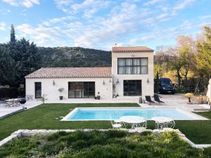 a house with a swimming pool in front of a yard at Villa Victoire - Mini villas avec terrasse privée in Vauvenargues
