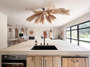 a kitchen with a sink and a large window at Villa Victoire - Mini villas avec terrasse privée in Vauvenargues