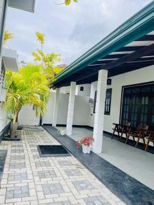 a patio of a house with two palm trees at Sahas Homestay in Tangalle