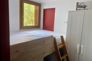 una cama en una habitación con ventana en Bright apartment near the slopes, en La Salle-les-Alpes