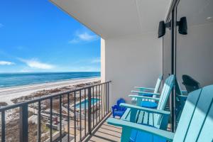 a balcony with blue chairs and the beach at Island Winds East Condo 402 in Gulf Shores