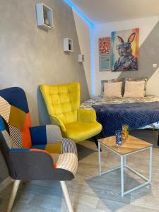 une chambre avec un lit, une chaise et une table dans l'établissement Les studios Happy - Local vélo, à Verdun-sur-Meuse 1 autre photo