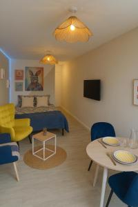 une chambre avec un lit, une table et des chaises dans l'établissement Les studios Happy - Local vélo, à Verdun-sur-Meuse