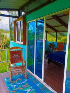 a house with glass doors and a chair on a porch at El Huerto del Edén in Armenia