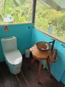 a bathroom with a toilet and a table and a window at El Huerto del Edén in Armenia