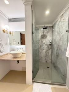 a bathroom with a glass shower and a sink at Hotel Amoek in Cartagena de Indias +50 photos