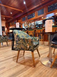 een stoel in een restaurant met een bar bij Brit Hotel L'Arrivée Guingamp in Guingamp