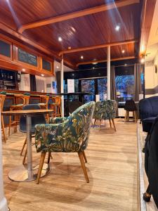 a room with chairs and tables in a restaurant at Brit Hotel L'Arrivée Guingamp in Guingamp