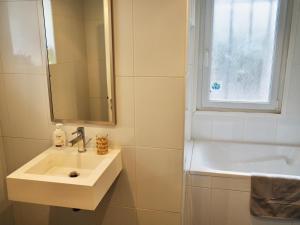 een badkamer met een wastafel, een bad en een raam bij Charmante Villa 5 min de la plage et garage in Le Touquet-Paris-Plage +17 foto's
