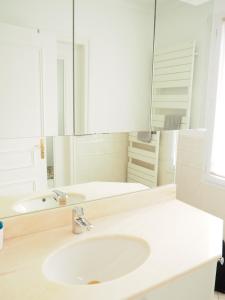 een witte badkamer met een wastafel en een spiegel bij Charmante Villa 5 min de la plage et garage in Le Touquet-Paris-Plage