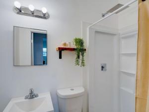 a bathroom with a toilet and a sink and a mirror at Miami Luxury Studio, Close to Wynwood and Beach in Biscayne Park