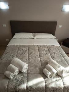 a large bed with three rolled towels on it at 2 passi dalla fiera SOGNI D'ORO in Verona