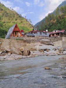 a group of houses on the banks of a river at Nirvana River Nest in Sainj