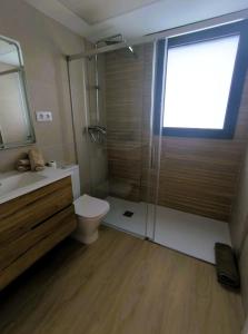 a bathroom with a shower and a toilet and a sink at Les Flors de Cunit Villa Edelweiss in Cunit