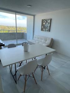 a living room with a table and chairs and a couch at Altamira Surubi-i in Estancia Sarubi