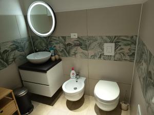 a bathroom with a toilet and a sink and a mirror at 2 passi dalla fiera SOGNI D'ORO in Verona +21 photos