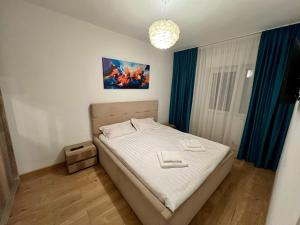 une chambre avec un lit et un tableau au mur dans l'établissement Central Vibe, à Curtea de Argeş