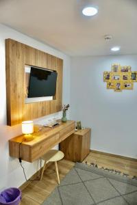 a room with a desk with a television on a wall at Casa Tapada do Bento II- Albufeira in Albufeira