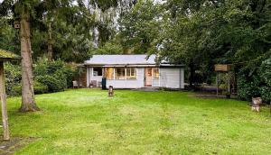 une petite maison blanche au milieu d'une cour dans l'établissement rustig gelegen met prachtig vrij uitzicht over natuurgebied, à Oude Willem