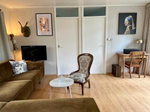 un salon avec un canapé et une table dans l'établissement rustig gelegen met prachtig vrij uitzicht over natuurgebied, à Oude Willem