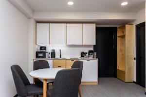 a kitchen with a table and chairs and a kitchen with white cabinets at 1BR Apart In Kokhta Mitarbi in Bakuriani