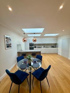 ein Esszimmer mit einem Tisch und blauen Stühlen in der Unterkunft Charming Ensuite Retreat in a Premier Location in Brentford