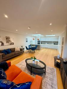 ein Wohnzimmer mit Sofa und Tisch in der Unterkunft Charming Ensuite Retreat in a Premier Location in Brentford
