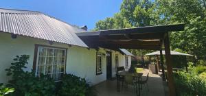 a patio of a house with a table and chairs at eMkhosini Royal Sun in Underberg