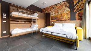 a bedroom with two beds and a tree mural at L'essenza Chalet - San Pietro 8A Valdisotto in Bormio