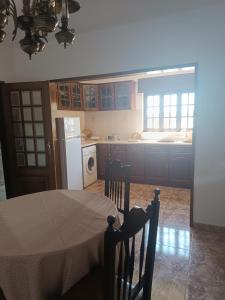 a kitchen with a table and a white refrigerator at Casa Das Manas - Pardais in Alandroal