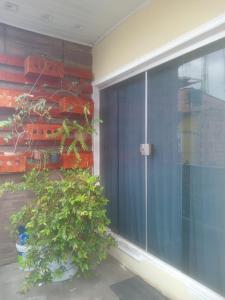 a sliding glass door with a potted plant next to it at Kit Net perto da vila cop30 in Belém